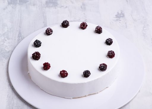 A closeup  shot of white-layered cake topped with fresh berries