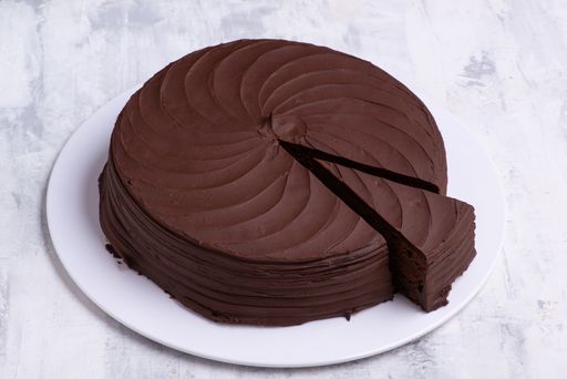 A closeup shot of a single-layered chocolate cake on a white plate