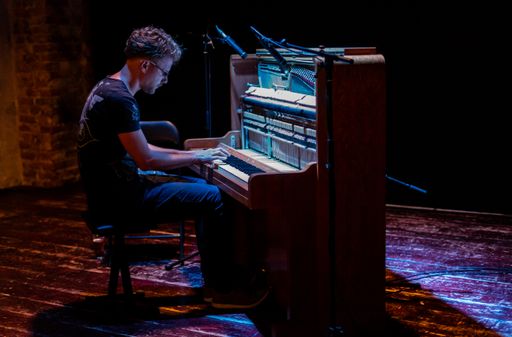 Male pianist playing on an old piano