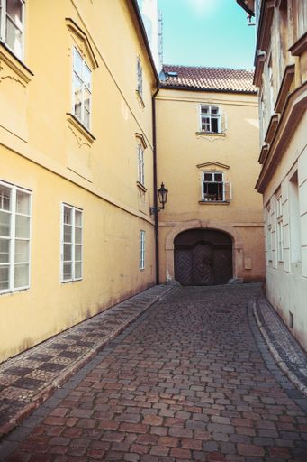 A vertical shot of a narrow street surrounded by buildings in Prague, Czech Republic