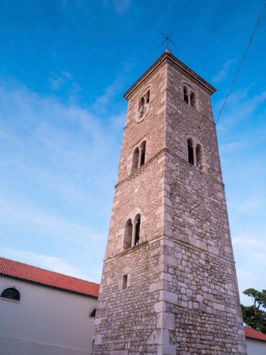A low angle shot of Bell tower of the Church of St. Anselm under blue bright sky