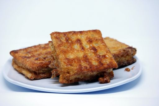 A closeup shot of grilled sandwiches on a plate isolated on the white background