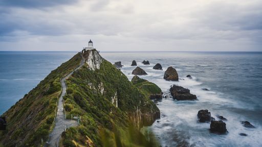A photo of Nugget Point Lighthouse, Catlins, New Zealand and a cloudy sky
