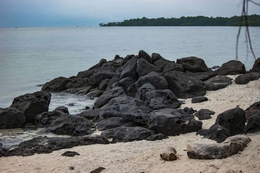 A seashore full of big black rocks - background concept