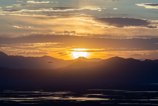 An Airplane Landing at Salt Lake City International with Sun Setting Over the Great Salt Lake