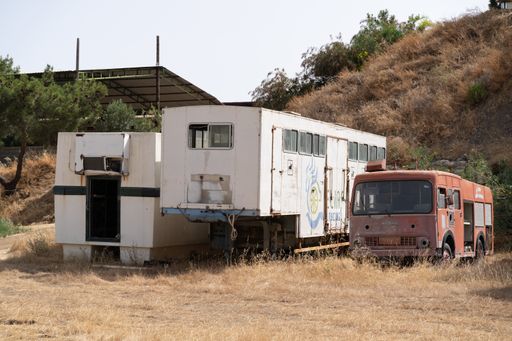 Limassol, Cyprus - June 2020: Abandoned horse wagons and fire track in desert landscape of a horse farm