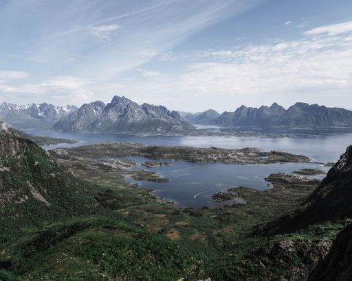 A aerial shot of a high mountains and ocean water in Lofoten archipelago in Norway
