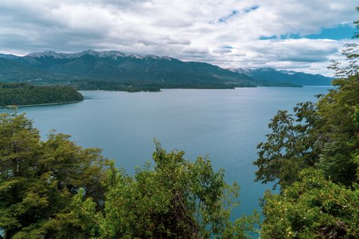 A landscape view of the lake in National park Bosque de Arrayanes, surrounded by trees and hills