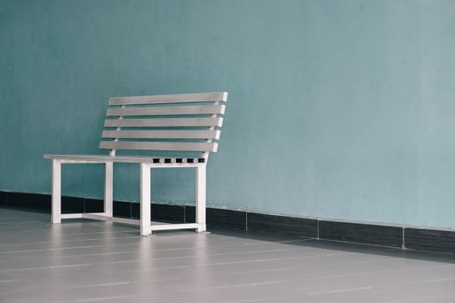A white bench against a blue wall in a waiting room