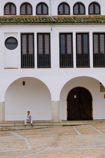 A man sitting in front of building of Garrovillas in Extremadura Spain a beautiful mediaeval town.