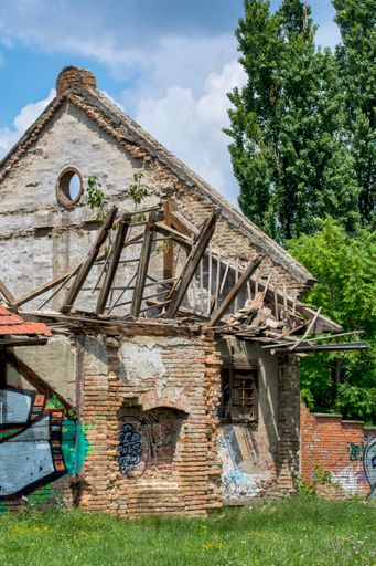 A vertical shot of an old stone building with a collapsed roof in Zrenjanin, Serbia