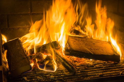 A closeup shot of a burning fire in the fireplace in the darkness