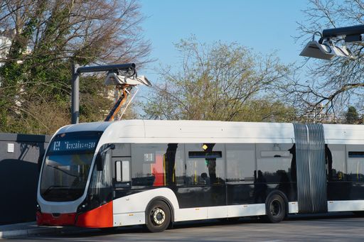 A large electric bus charging at a charging station,drive of the future
