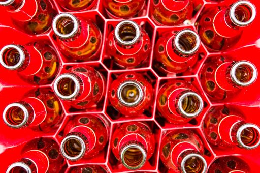 An overhead shot of empty glass bottles on red boxes - perfect for background