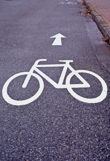 A vertical shot of a painted bicycle lane sign