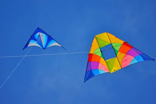 A closeup of colorful kites isolated on a blue sky background