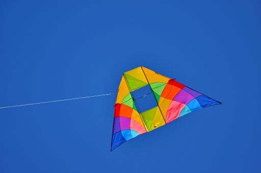 A colorful kite flying in the blue clear sky