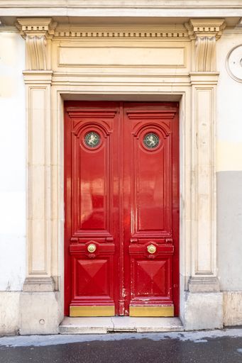 Paris, an ancient wooden door, beautiful decorated facade in the 11e arrondissement