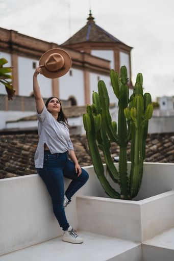 a vertical shot of girl holding hat above her head
