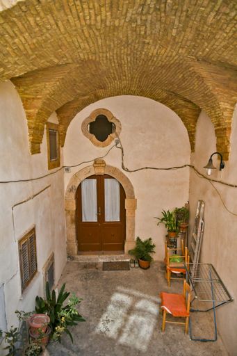 A vertical of old arcade stone buildings and narrow streets in Candela village in Puglia,Italy