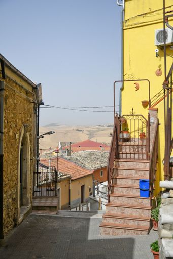A vertical of old yellow beautiful buildings and narrow streets in Candela village in Puglia,Italy