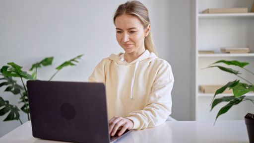 A closeup shot of a Caucasian woman working with her computer at home
