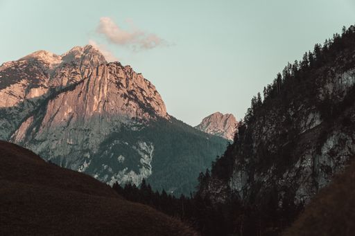 A beautiful shot of a mountain covered with snow in Austria with a cloudy blue sky in the background