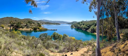 A Dixon lake surrounded by green trees and bushes in background of greenery mountains in Escondido