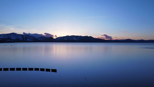A beautiful a purple seascape view during blue sunset under a blue cloudy sky horizon