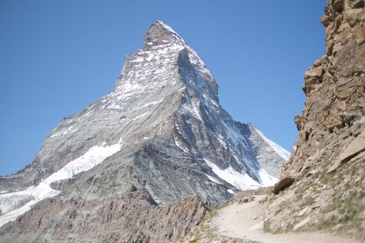 A low angle shot of the rocky Matterhorn mountain against a blue sky in the Switzerland Alps