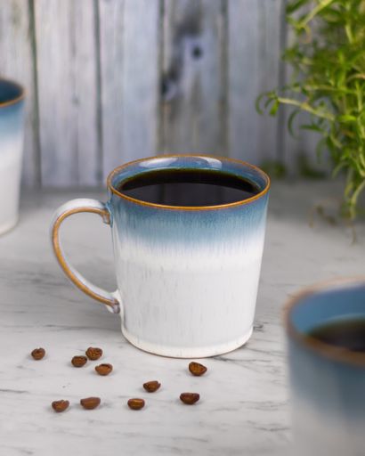 A beautiful shot of a delicious cup of coffee and coffee beans on a table
