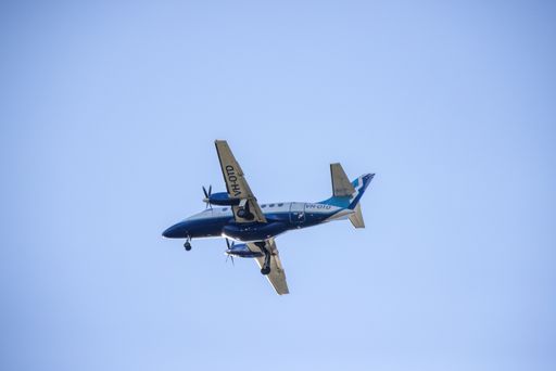 A low angle shot of the VH-OTD Australian aircraft flying with blue sky in the background, town Mudgee