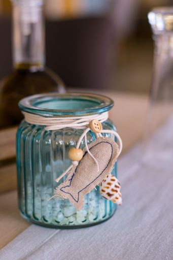 A vertical closeup shot of a blue glass bank with hanging fish decoration