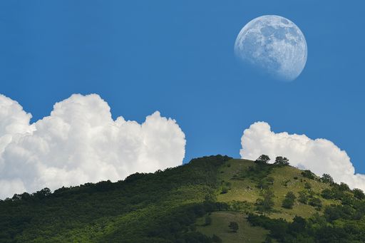 A mesmerizing landscape shot of the moon vibrant on broad day light