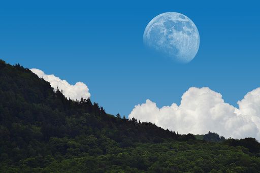 A mesmerizing landscape shot of the moon vibrant on broad day light