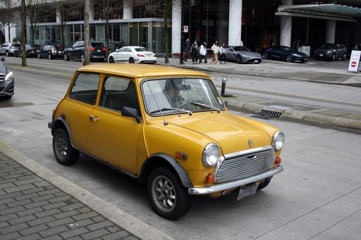 A yellow Mini Cooper car in downtown Vancouver, British Columbia, Canada