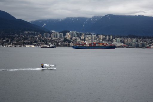 A seaplane and container ship in Vancouver Harbour, British Columbia, Canada