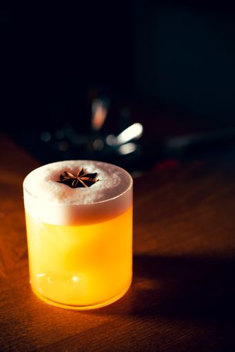 A vertical shot of a refreshing cocktail on a wooden table.