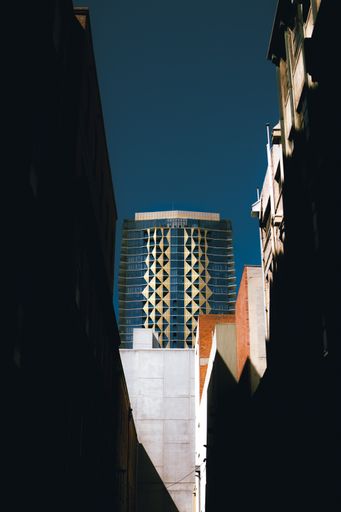 A vertical shot of the modern Realm Apartments skyscraper in Adelaide against a blue sky