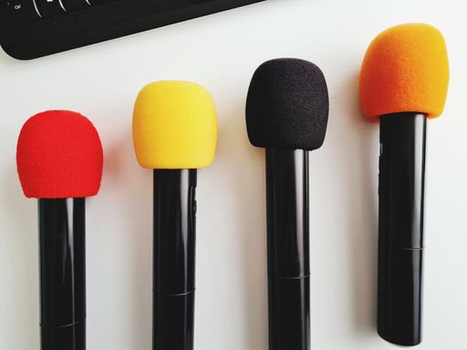A wallpaper of colored microphones in a row resting on the desk