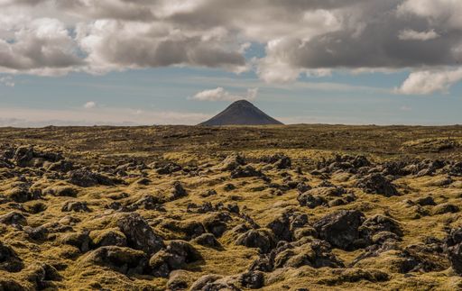 A vulcanized mountain Keilir sticking out of the moss field on a sunny day in Iceland