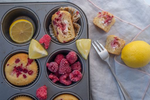 A top view of delicious freshly bakes raspberry cupcakes in a metal tin with a fork next to them