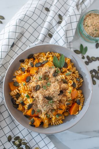 A vertical top view shot of a bowl of delicious freshly cooked pasta with pumpkin