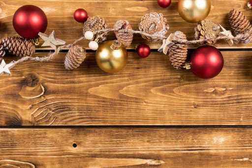 A closeup shot of Christmas toys and pinecones on the wooden background
