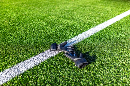 a wide shot of a goalkeeper gloves lying on soccer pitch