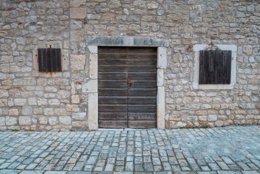 A traditional stone wall with doors and windows