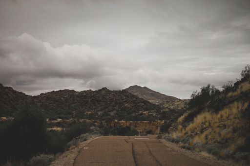 A beautiful view of a road and mountains under the cloudy sky