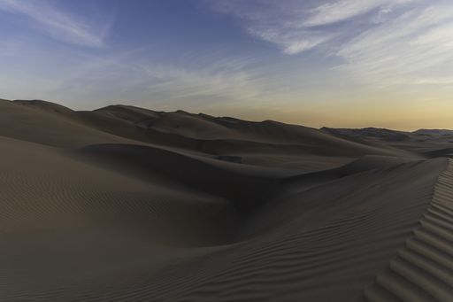 A beautiful view of sand dunes in Reserved Zone Laguna de Huacachina in Peru in the sunset