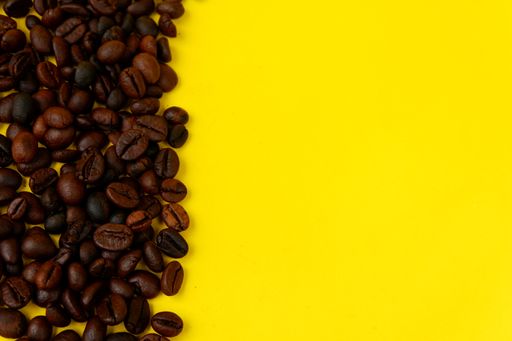 A closeup shot of coffee beans on a yellow background