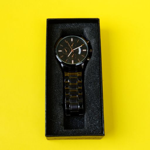 A vertical shot of a luxury wristwatch on a black gift box against a yellow background